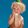 bare_chest, blue_sky, celebration, child, curly_hair, cute, daylight, hands, happy, joy, orange_shorts, outdoor, party_hat, person, playful, portrait, skin, smiling, summer, toddler
