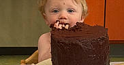 Royal is registered to the contest to win money with this photo: child, toddler, cake, chocolate_cake, chocolate, strawberries, food, messy, face, blue_eyes, hair, kitchen, orange_cabinet, table, plate, fingers, eating, happy, indoor, person