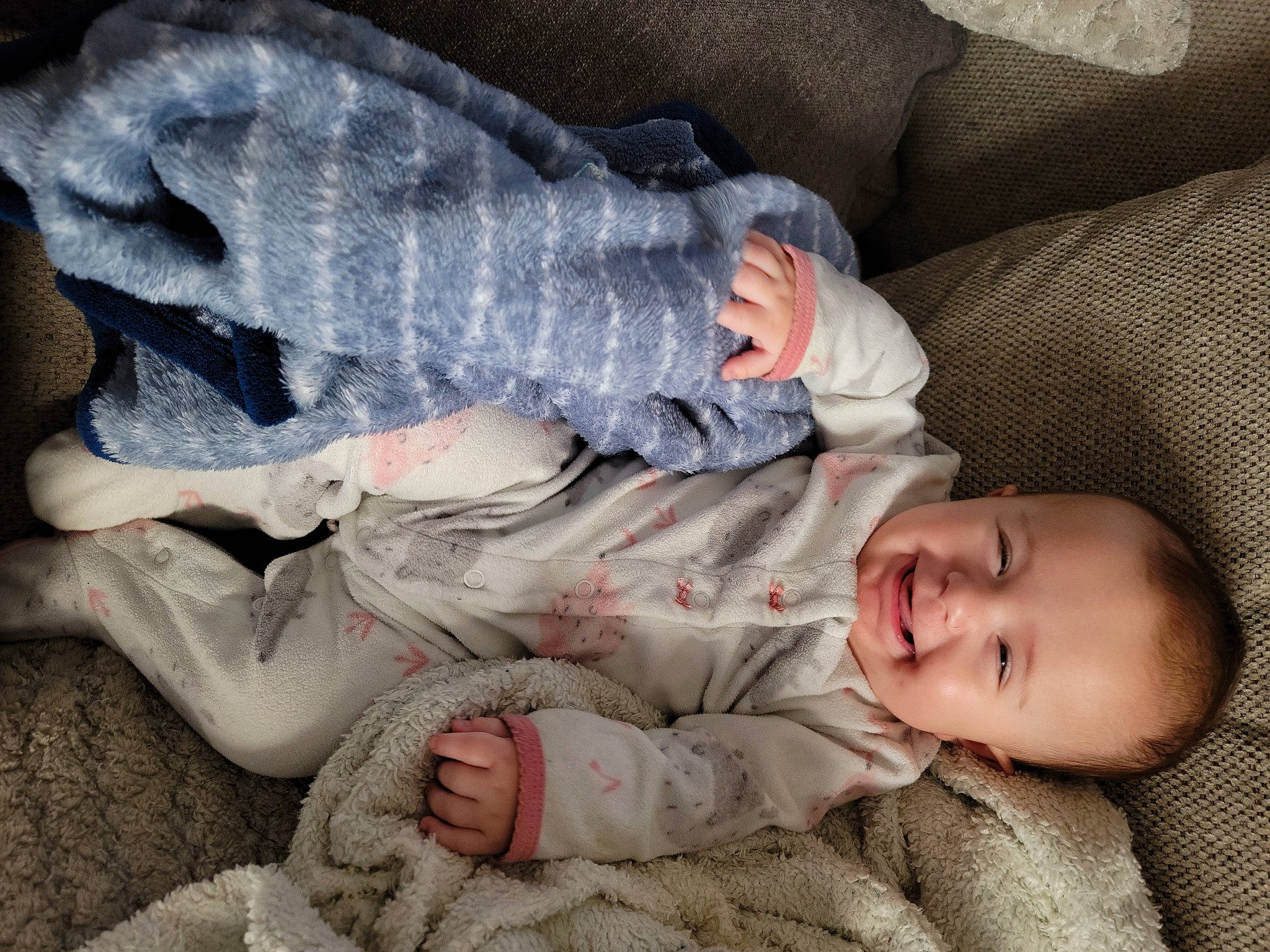 Lacey is registered to the contest to win money with this photo: baby, baby_toddler_clothing, comfort, elbow, eye, finger, foot, gesture, grey, hand, head, human_leg, joy, leg, linens, person, skin, sleeve, textile, thigh