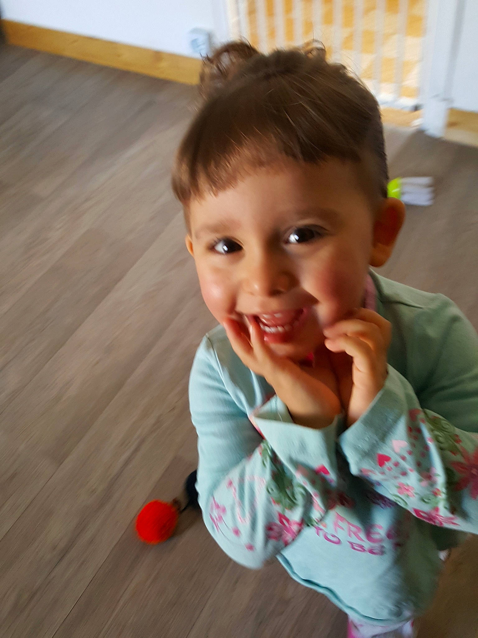 Emilie a rejoint le concours — aidez-le/la à gagner de superbes lots ! baby, cheek, child, chin, face, floor, flooring, fun, head, lip, mouth, nose, person, play, skin, smile, standing, toddler, wood