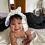 baby, diaper, crawling, smiling, indoor, bed, white_bedspread, child, happy, cute, chubby, person, headwear, playful, infant, skin, room, door, furniture, blanket