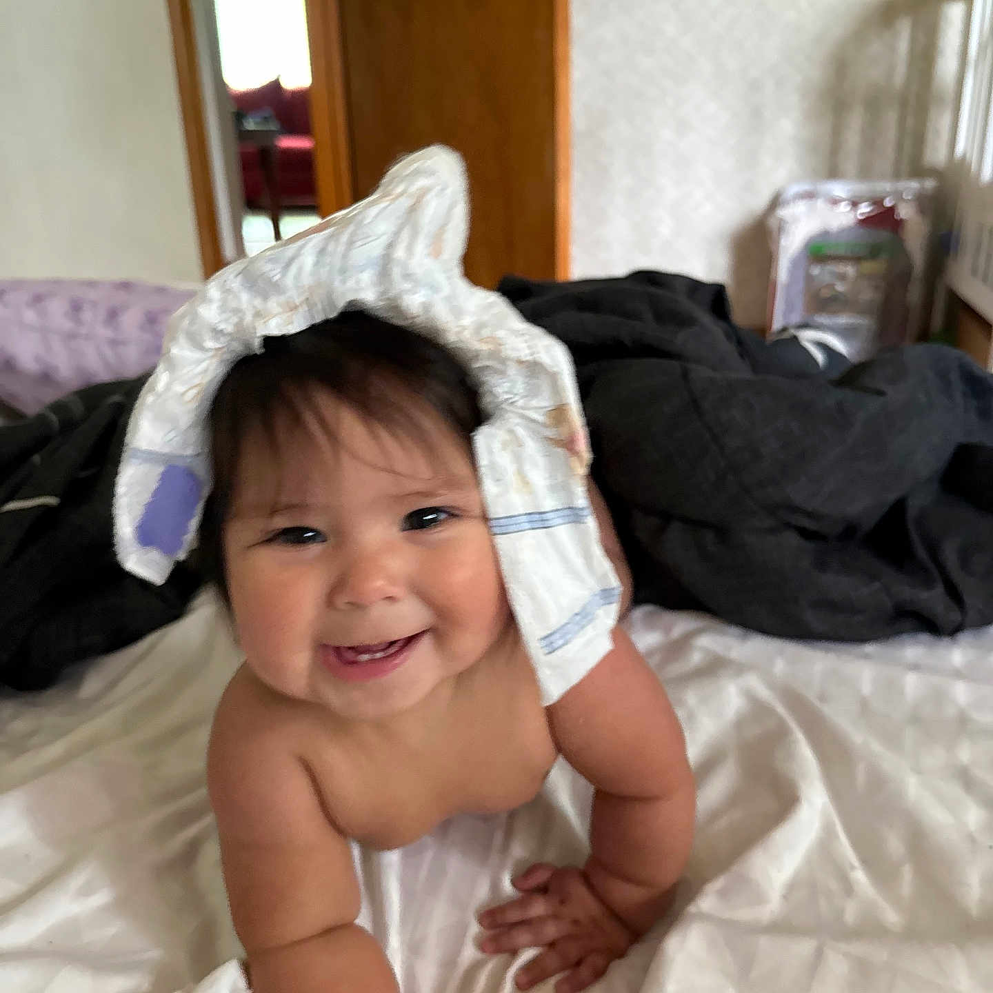 Scarlett is registered to the contest to win money with this photo: baby, bed, blanket, child, chubby, crawling, cute, diaper, door, furniture, happy, headwear, indoor, infant, person, playful, room, skin, smiling, white_bedspread