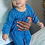 adult_hand, baby, bed, bedspread, casual_clothing, child, curious, cute, denim_outfit, earring, foot, hand, holding, indoor, infant, jeans, person, portrait, skin, white_tank_top
