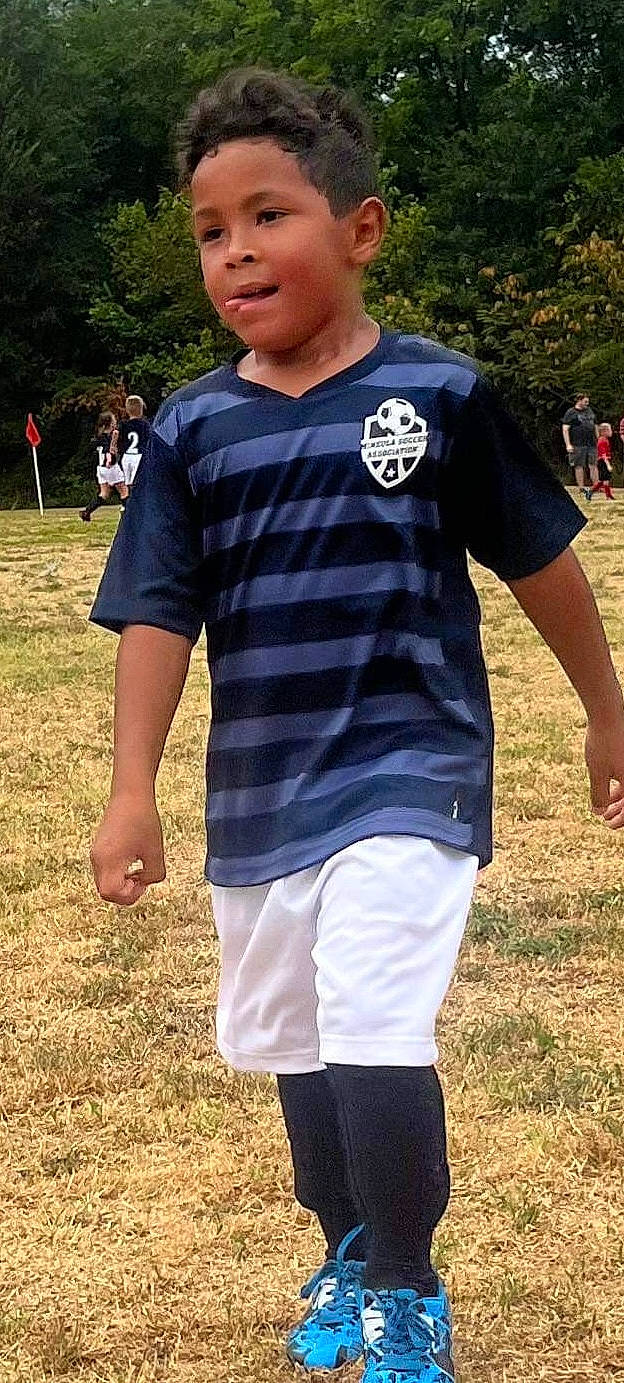 Terrell is registered to the contest to win money with this photo: active_shirt, electric_blue, eyewear, fun, gesture, grass, happy, human_leg, leisure, neck, pattern, person, player, recreation, shoulder, sleeve, sportswear, t_shirt, textile, thigh