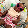 Novah joined the competition — help win amazing prizes! baby, child, infant, sunglasses, smiling, sitting, bouncer, baby_seat, pink, outfit, bib, patterned_clothing, indoor, home, wooden_floor, door, photography, portrait, playful, fashion
