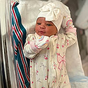 Germany-Rose is registered to the contest to win money with this photo: newborn, baby, infant, child, portrait, hospital, bassinet, blanket, hat, bow, floral_clothing, onesie, mittens, sleeping, awake, face, eyes, indoor, nursery, photography