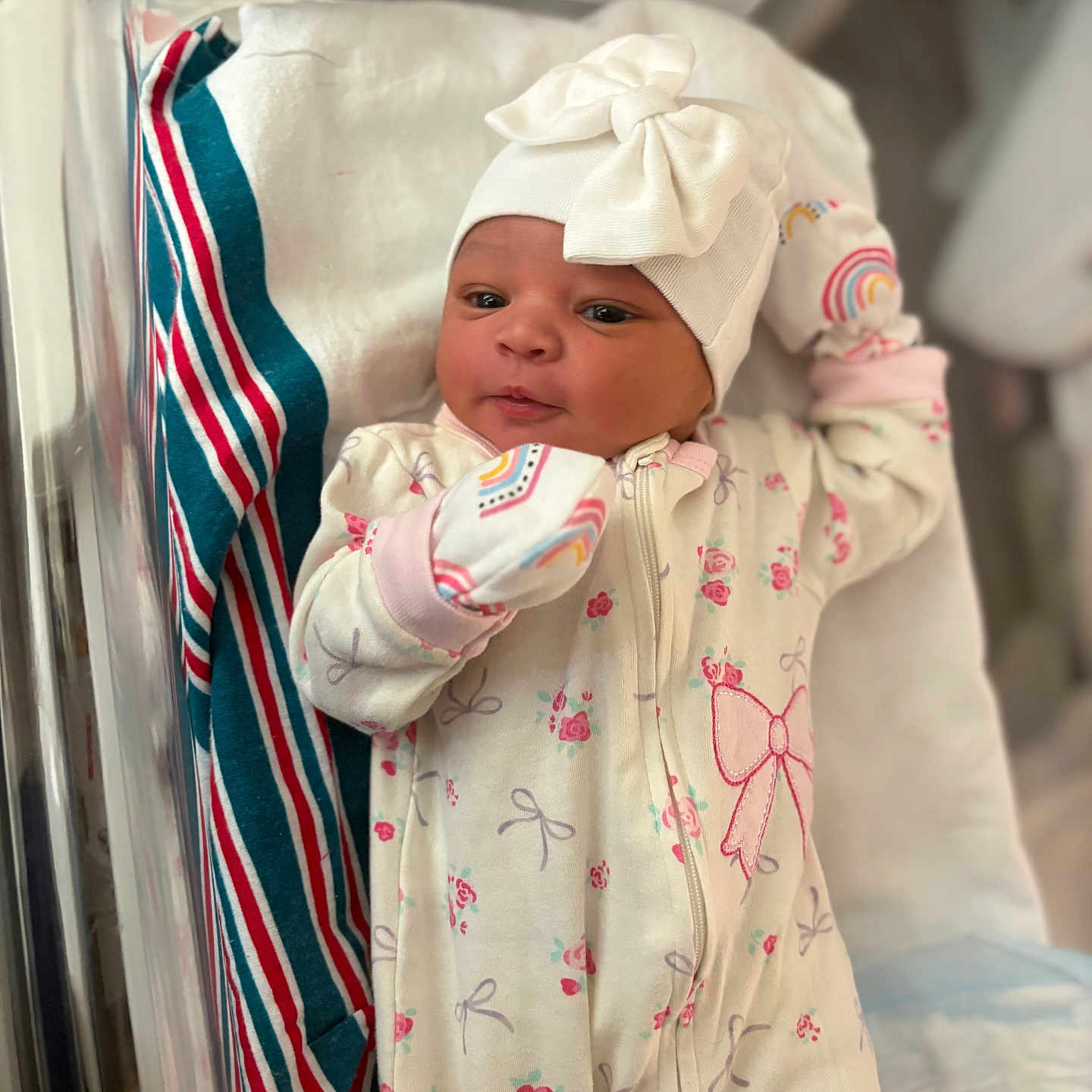 Germany-Rose is registered to the contest to win money with this photo: newborn, baby, infant, child, portrait, hospital, bassinet, blanket, hat, bow, floral_clothing, onesie, mittens, sleeping, awake, face, eyes, indoor, nursery, photography