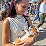 Aïko participe au concours pour gagner de l'argent avec cette photo : woman, puppy, dog, outdoor, market, people, smiling, holding, sunlight, casual_clothing, earrings, bracelet, watch, tattoo, background, buildings, street, crowd, daytime, happy