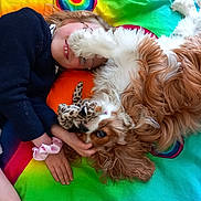 Ulya a rejoint le concours — aidez-le/la à gagner de superbes lots ! child, dog, pet, playing, cuddling, toy, colorful_blanket, rainbow, happy, smiling, glasses, long_hair, paw, fur, indoors, casual_clothing, relaxed, friendship, cute, comfort
