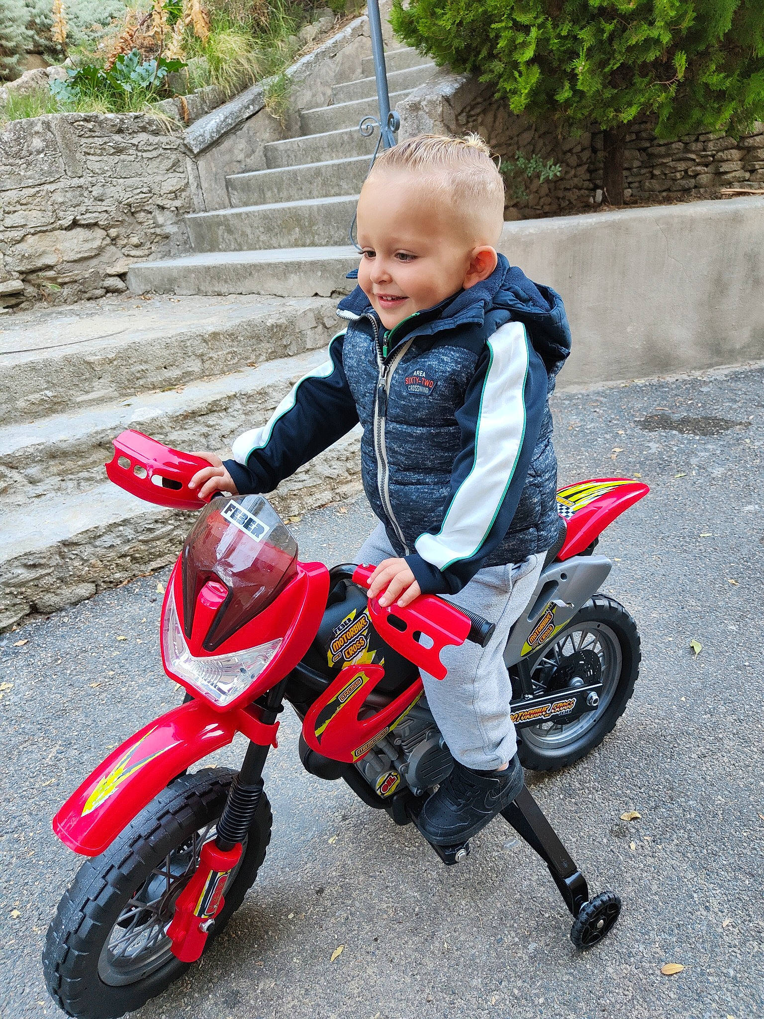 Thaïs participe au concours pour gagner de l'argent avec cette photo : auto_part, automotive_design, automotive_lighting, automotive_tire, automotive_wheel_system, baby_toddler_clothing, carmine, fender, joy, motor_vehicle, motorcycle, motorcycle_accessories, person, personal_protective_equipment, plant, recreation, rim, spoke, tire, toddler