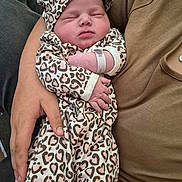 Keeley is registered to the contest to win money with this photo: newborn, baby, sleeping, infant, leopard_print, hat, onesie, person, adult_hand, cozy, cute, resting, soft, human, child, portrait, clothing, closeup, tender, warmth