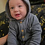 baby, background_blur, button, child, clothing, cozy, cute, expression, eyes, face, hand, happy, hood, indoors, infant, portrait, sitting, smile, soft, warm