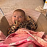 baby, infant, blanket, pink_blanket, leopard_print, cushion, seat, smile, face, cozy, indoor, child, clothing, head, happy, soft_texture, fabric, person, home, resting