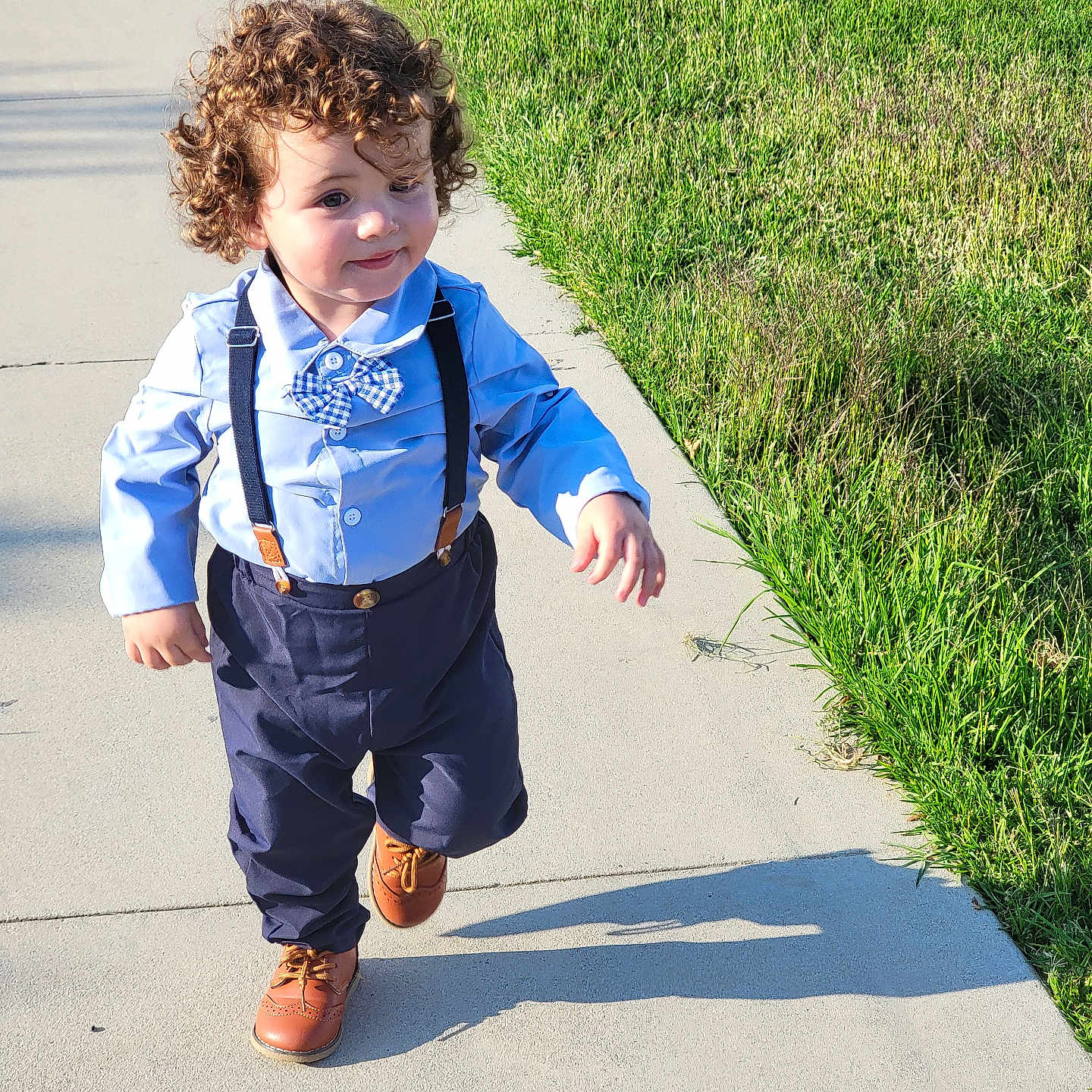 Gael is registered to the contest to win money with this photo: accessories, boy, child, clothing, face, footwear, formalwear, grass, head, male, pants, path, person, photography, plant, portrait, shorts, sidewalk, tie, walking