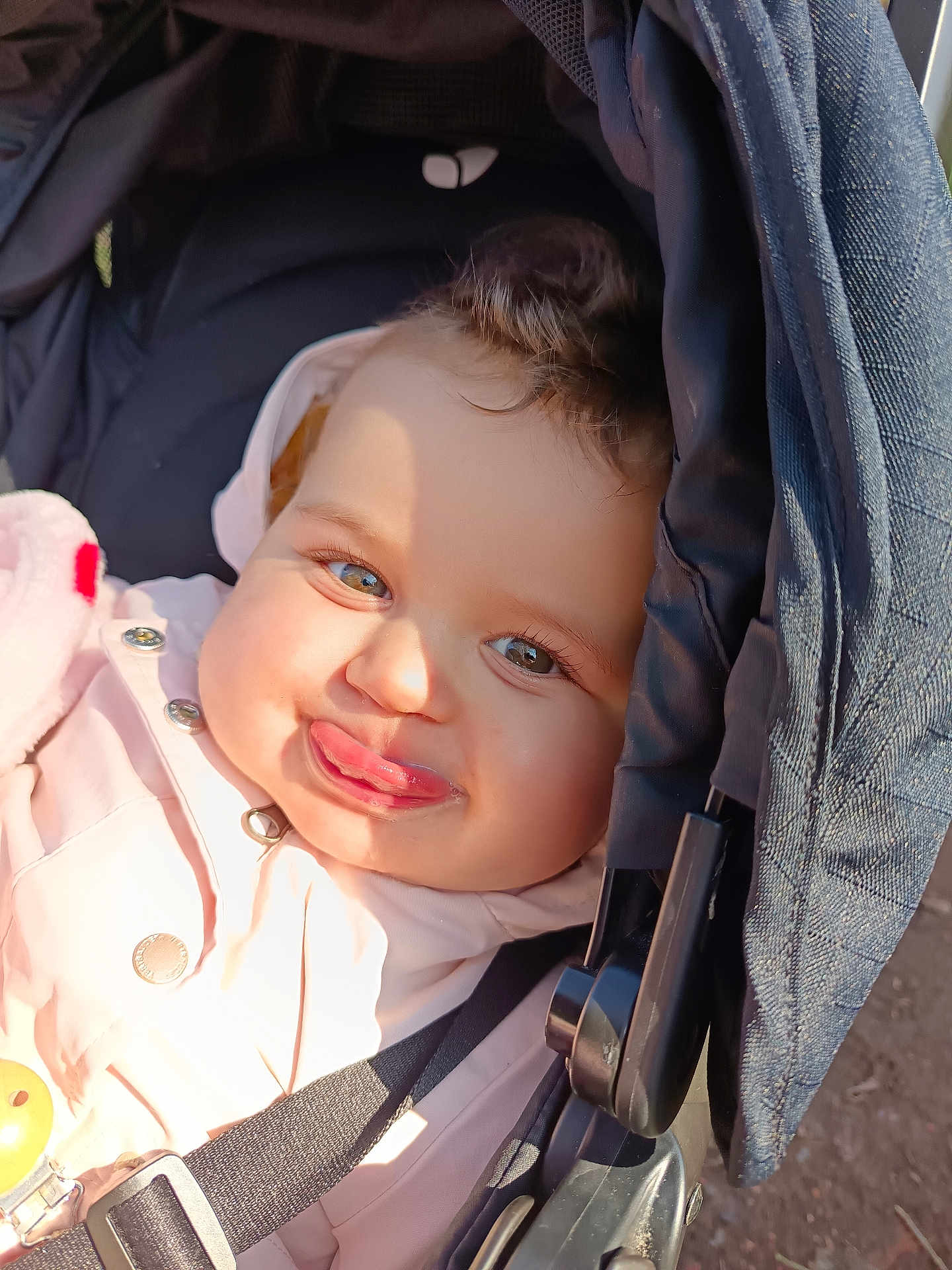 Lynda a rejoint le concours — aidez-le/la à gagner de superbes lots ! baby, infant, child, stroller, car_seat, face, tongue, smile, cheeks, eyes, eyelashes, jacket, coat, hood, sunlight, shadow, buckle, strap, portrait, outdoor