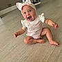 baby, child, infant, sitting, pink_bow, headband, knitted_outfit, happy, smiling, floor, wooden_floor, indoors, cute, young_child, person, expression, open_mouth, skin, barefoot, room