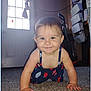 baby, child, crawling, carpet, smiling, indoor, door, curtain, person, floor, happy, young_child, clothing, blue_dress, face, hands, eyes, home, vacuum_cleaner, storage