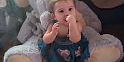 Ellaina is registered to the contest to win money with this photo: baby, child, plush_elephant, stuffed_animal, carpet, indoors, sitting, thumb_sucking, blue_dress, cute, soft_toys, floor, small_child, childhood, comfort, playroom, infant, adorable, cozy, home