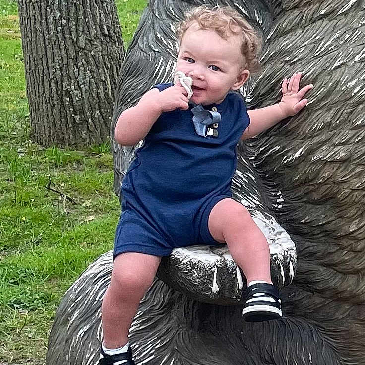 Damien joined the competition — help win amazing prizes! boy, child, clothing, face, footwear, grass, head, male, nature, outdoors, pants, park, person, photography, plant, portrait, shoe, shorts, sitting, tree