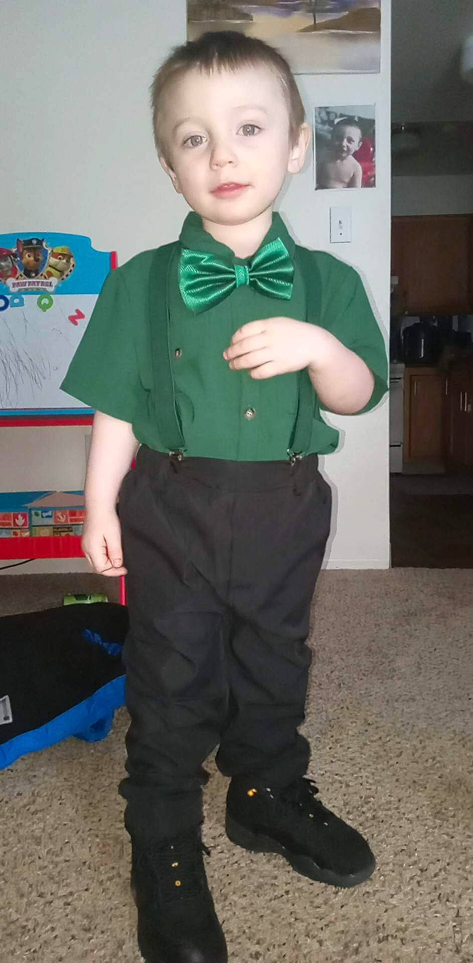 Liam is registered to the contest to win money with this photo: blazer, button, child, collar, costume, dress_shirt, event, fashion_accessory, fashion_design, formal_wear, fun, gesture, person, room, shelf, sleeve, t_shirt, tie, toddler, uniform