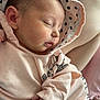 baby, sleeping, hoodie, pink_clothing, infant, cute, cozy, hand, face, polka_dot, soft_fabric, closeup, peaceful, child, newborn, warm, relaxed, cute_outfit, indoors, portrait