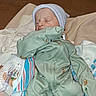 newborn, baby, sleeping, infant, portrait, indoors, bed, blanket, clothing, knit_cap, green_outfit, striped_blanket, swaddled, peaceful, face, closed_eyes, home, textile, cozy, photograph