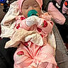 baby, sleeping, infant, pink_outfit, strawberry_pattern, hat, pacifier, mittens, blanket, car_seat, portrait, indoors, seated, peaceful, clothing, cuddly, face, head, baby_carrier, cozy
