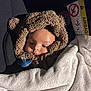 baby, child, car_seat, blanket, pacifier, hooded_clothing, bear_ears, soft_texture, infant, cute, warm, white_blanket, car_interior, seatbelt, face, portrait, young_child, cozy, sleepy, clothing