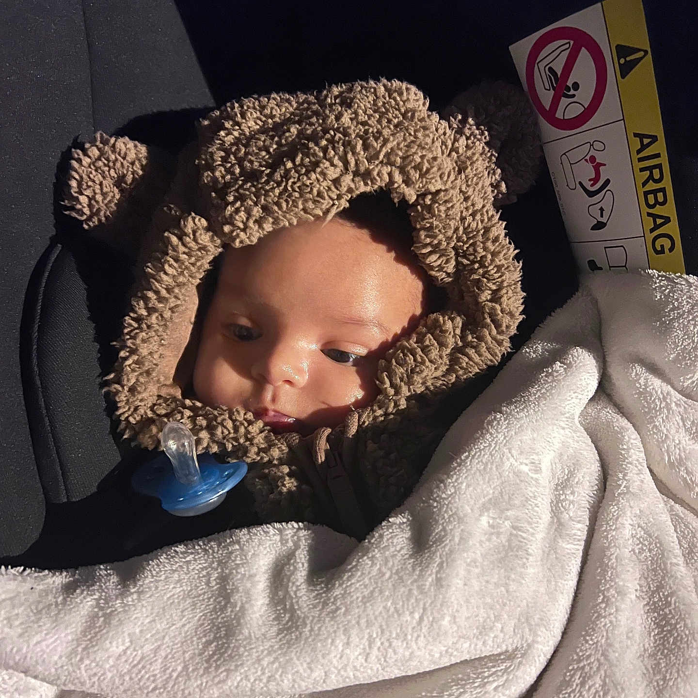 Zakaria a rejoint le concours — aidez-le/la à gagner de superbes lots ! baby, bear_ears, blanket, car_interior, car_seat, child, clothing, cozy, cute, face, hooded_clothing, infant, pacifier, portrait, seatbelt, sleepy, soft_texture, warm, white_blanket, young_child