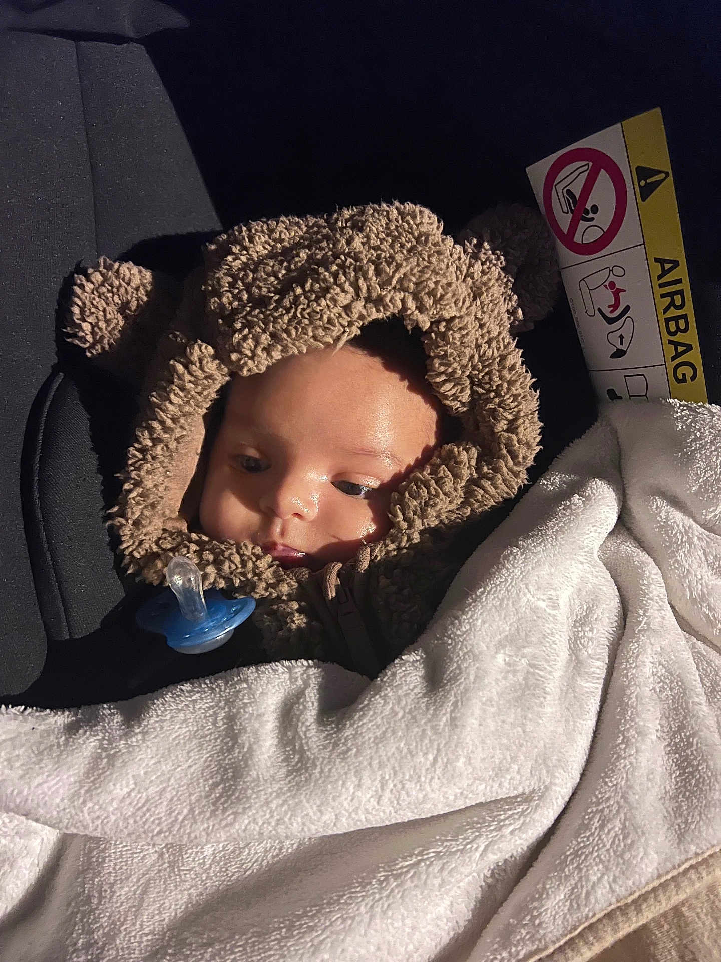 Zakaria a rejoint le concours — aidez-le/la à gagner de superbes lots ! baby, child, car_seat, blanket, pacifier, hooded_clothing, bear_ears, soft_texture, infant, cute, warm, white_blanket, car_interior, seatbelt, face, portrait, young_child, cozy, sleepy, clothing