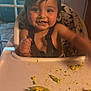 baby, high_chair, food, avocado, messy_face, child, indoor, window, star_pattern, cushion, tray, happy, cute, eating, smiling, hair, face, hand, table, infant