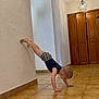 Adil joined the competition — help win amazing prizes! child, toddler, wall_handstand, handstand, tile_floor, indoor, wall, shorts, barefoot, wooden_wardrobe, ceiling_lamp, light_fixture, adult_peeking, balancing, person, home_interior, floor_tile, arm_support, plaster_wall, playful_pose