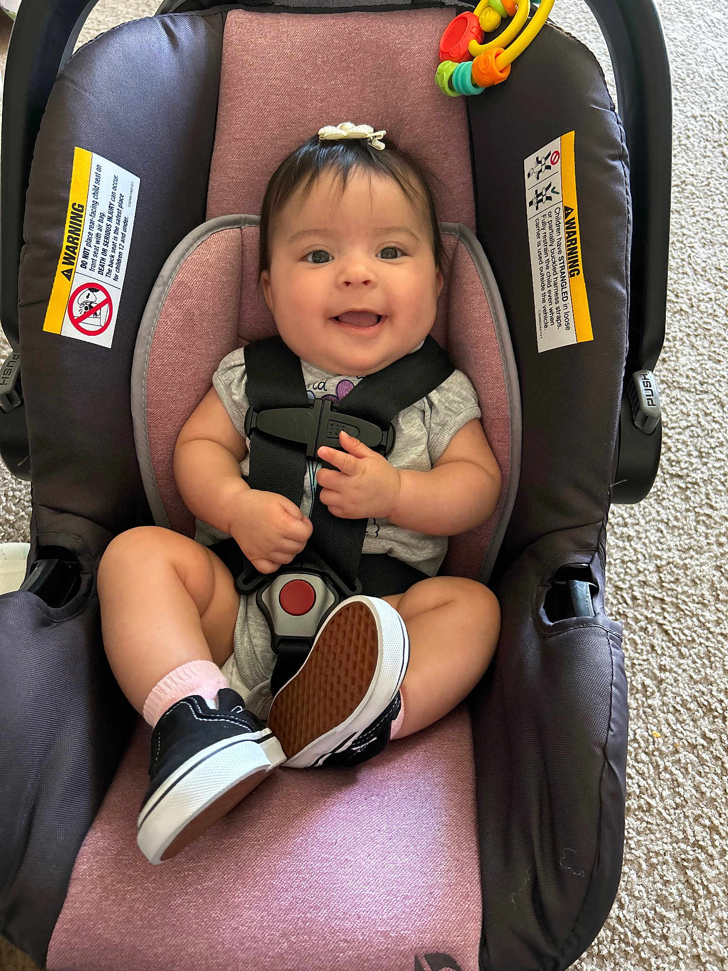 Aaliyah joined the competition — help win amazing prizes! baby, car_seat, smile, sneakers, infant, child, seatbelt, happy, indoor, toy, hair_bow, pink, black_shoes, car_seat_straps, carpet, clothing, person, cute, small_hands, infant_shoes
