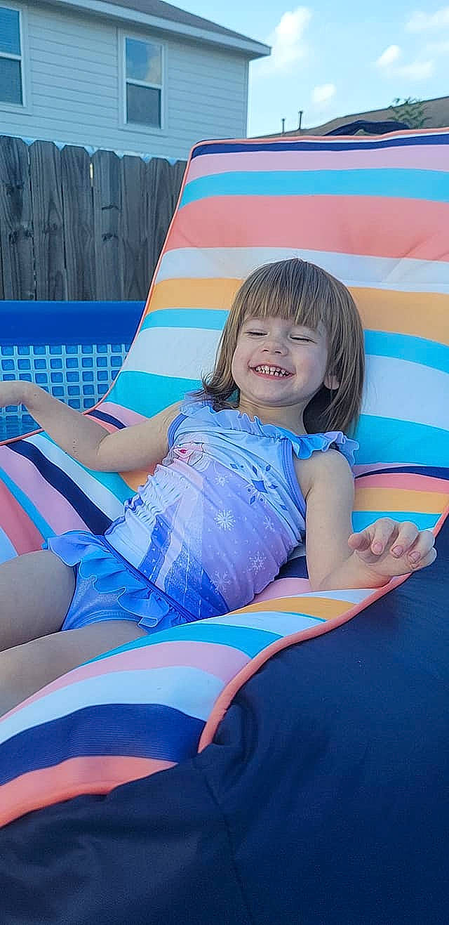 Leelah joined the competition — help win amazing prizes! arm, blue, child, comfort, elbow, electric_blue, fun, happy, human_body, human_leg, joy, knee, lap, leisure, magenta, outdoor_furniture, person, recreation, sitting, smile