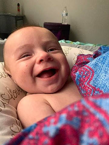 Lukka is registered to the contest to win money with this photo: baby, baby_laughing, bed, cheek, chin, comfort, eye, face, happy, head, iris, mammal, mouth, nose, person, plaid, skin, smile, tartan, toddler