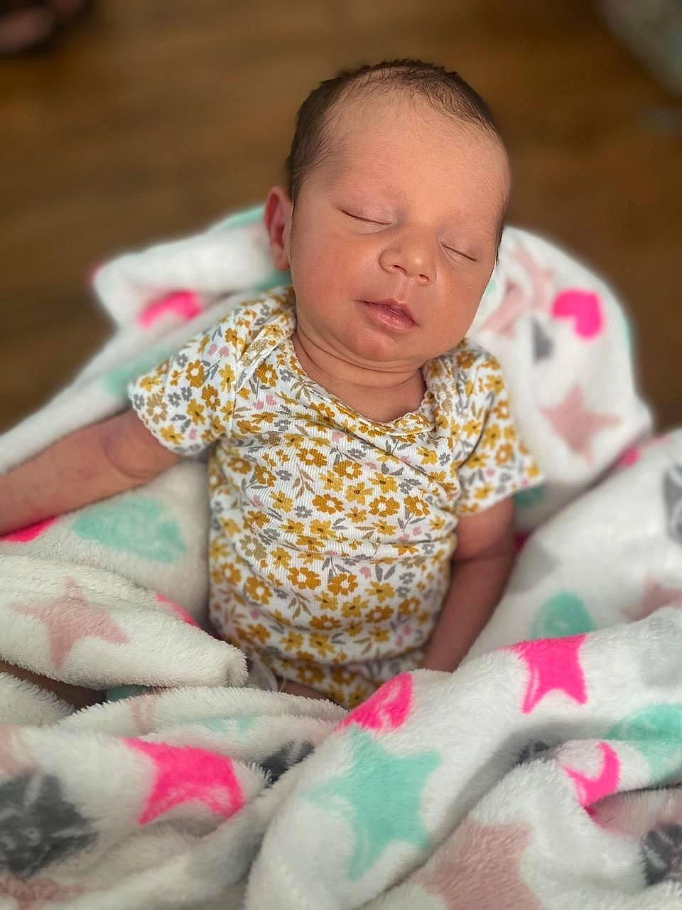 Liliana is registered to the contest to win money with this photo: baby, baby_toddler_clothing, cheek, child, comfort, facial_expression, finger, fun, happy, head, linens, magenta, person, pink, play, room, sitting, skin, t_shirt, textile