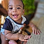 toddler, child, smiling, happy, face, hands, wooden_table, indoor, closeup, cute, baby, person, skin, short_sleeve, black_hair, expression, playful, young, portrait, fingers
