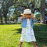 Jade is registered to the contest to win money with this photo: child, girl, dress, denim_jacket, hat, straw_hat, park, grass, trees, sunny, daytime, playful_pose, footwear, shoes, outdoor, nature, person, greenery, leisure, cute