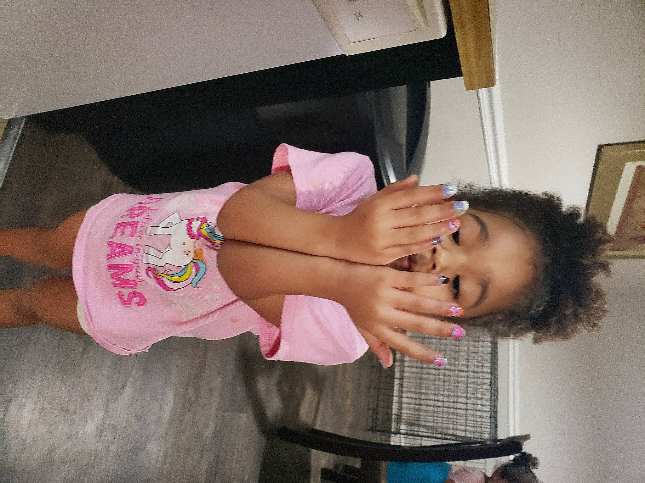 Taegan is registered to the contest to win money with this photo: abdomen, chair, elbow, eyelash, finger, fun, human_leg, knee, mouth, nail, person, picture_frame, room, shorts, sleeve, t_shirt, thigh, thumb, toddler, trunk