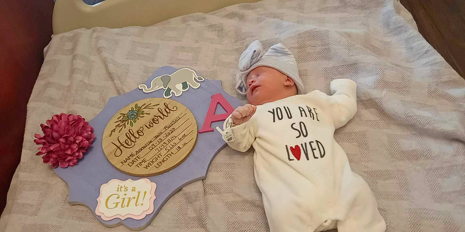 Annalise is registered to the contest to win money with this photo: baby, baby_toddler_clothing, baseball_cap, bedding, cap, child, comfort, font, handwriting, happy, hat, hoodie, linens, pattern, person, petal, sleeve, sweetness, t_shirt, textile