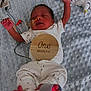 Kyrie joined the competition — help win amazing prizes! baby, newborn, infant, sleeping, hospital, medical_wires, sensor, foot_sensor, onesie, plaque, wooden_sign, milestone, blanket, star_pattern, cute, peaceful, lying_down, indoors, child, one_month