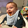 Jameson joined the competition — help win amazing prizes! baby, high_chair, bib, food, messy, smile, happy, indoor, child, clothing, face, person, table, feeding, orange_food, cute, infant, toddler, expression, blurred_background