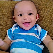 Grant-Ezra is registered to the contest to win money with this photo: baby, smiling, happy, infant, blue_striped_onesie, couch, indoor, child, portrait, cute, young_child, sitting, face, skin, person, one_person, casual_clothing, home, comfortable, joyful