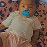 Aniyah joined the competition — help win amazing prizes! baby, pacifier, curly_hair, infant, blanket, patterned_blanket, shirt, giraffe_design, pink_shorts, child, cute, indoors, relaxed, lying_down, soft_lighting, portrait, toddler, skin, face, comfort