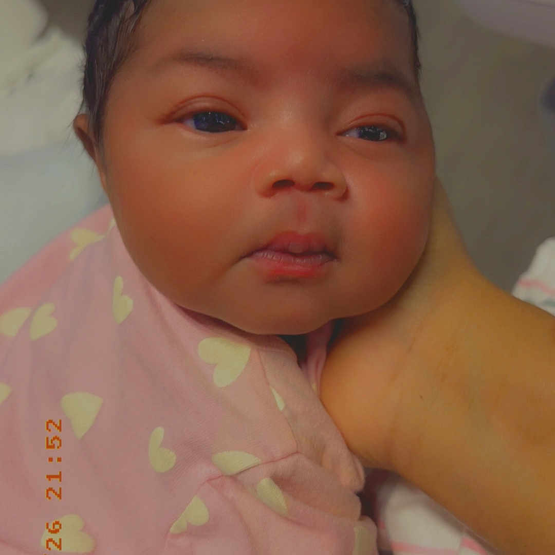 Aniyah joined the competition — help win amazing prizes! baby, infant, child, pink_blanket, heart_pattern, face, hand, skin, portrait, indoors, soft_lighting, newborn, curious, cute, closeup, wrapped, sleepy, resting, person, warm