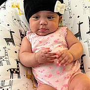 Hope joined the competition — help win amazing prizes! arms, baby, beanie, bow, child, close_up, cushion, face, giraffe_pattern, hands, indoor, infant, legs, looking_at_camera, lying_down, onesie, pink_outfit, portrait, safe, sitting