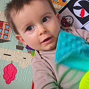 Adrián a rejoint le concours — aidez-le/la à gagner de superbes lots ! toddler, child, toy, playmat, indoor, face, curious, young_child, casual_clothing, patterned_background, happy, infant, person, small_hands, bright_eyes, colorful, soft_lighting, closeup, portrait, candid