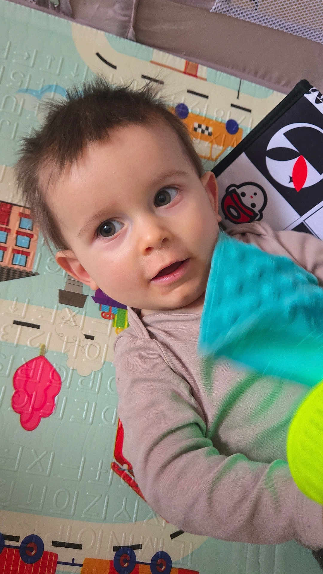 Adrián a rejoint le concours — aidez-le/la à gagner de superbes lots ! toddler, child, toy, playmat, indoor, face, curious, young_child, casual_clothing, patterned_background, happy, infant, person, small_hands, bright_eyes, colorful, soft_lighting, closeup, portrait, candid