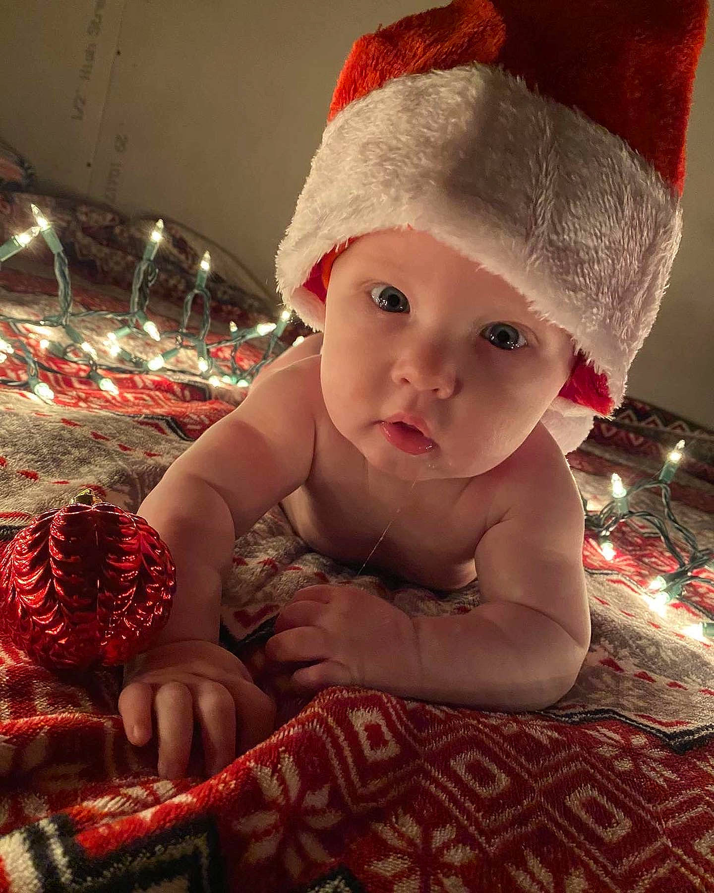 Keegan is registered to the contest to win money with this photo: baby, baby_toddler_clothing, cap, child, christmas, christmas_eve, costume_hat, eye, fashion_accessory, flash_photography, happy, hat, headwear, holiday, human_body, lip, person, pink, room, skin