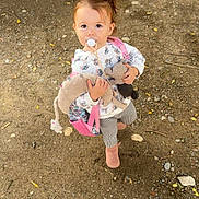 Heiana participe au concours pour gagner de l'argent avec cette photo : toddler, child, pacifier, plush_toy, backpack, outdoor, dirt, gravel, boots, long_sleeve, patterned_pants, vehicle_tire, curious, standing, daylight, nature, young_child, casual_clothing, small_person, playful